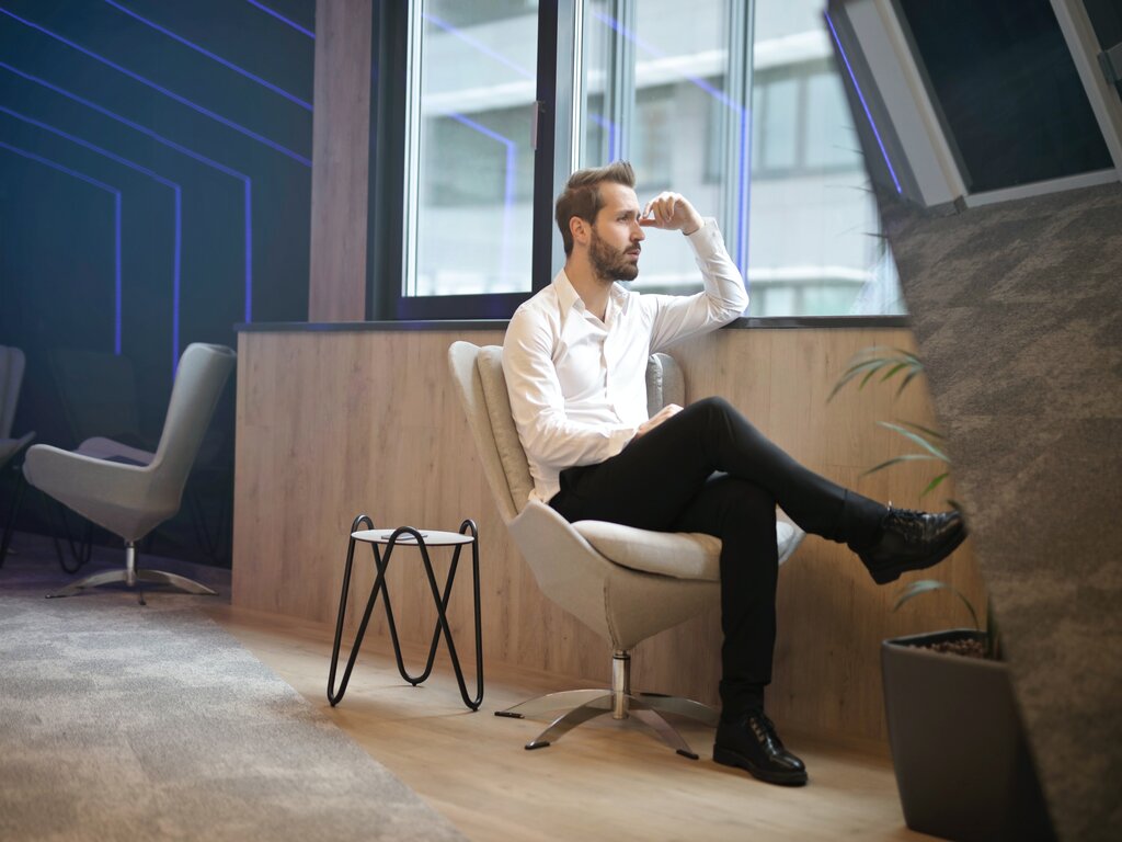 Man sitting beside a window and overthinking