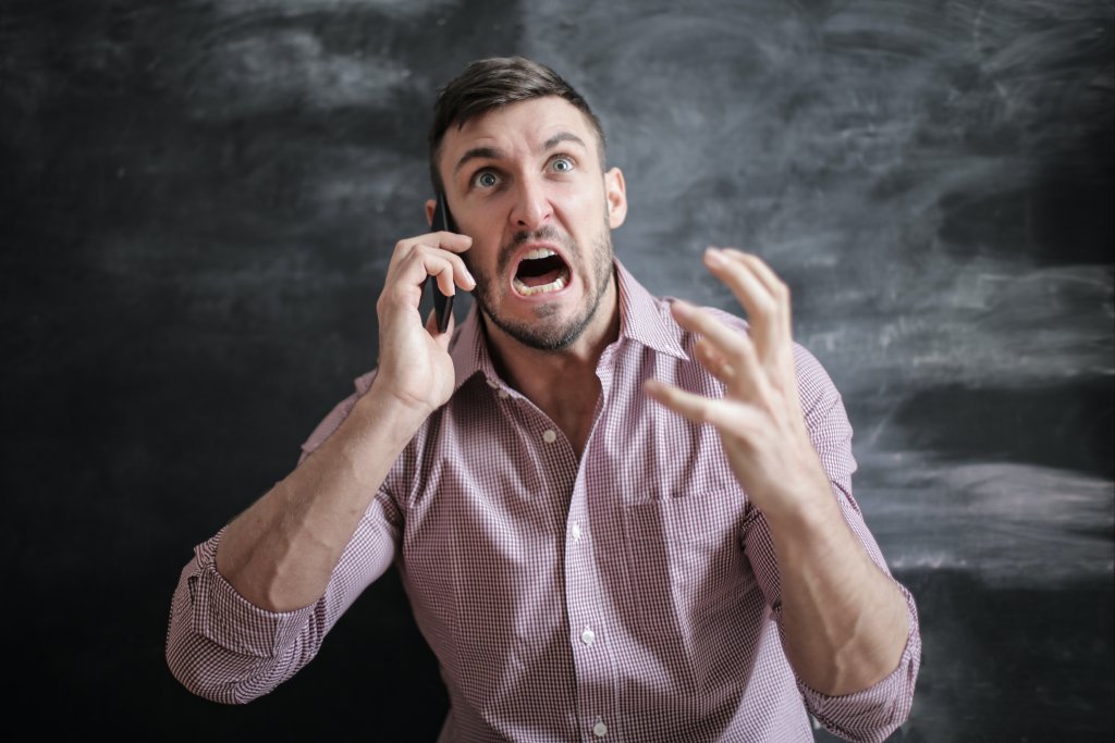 An enraged man over a phone call trying to control his anger