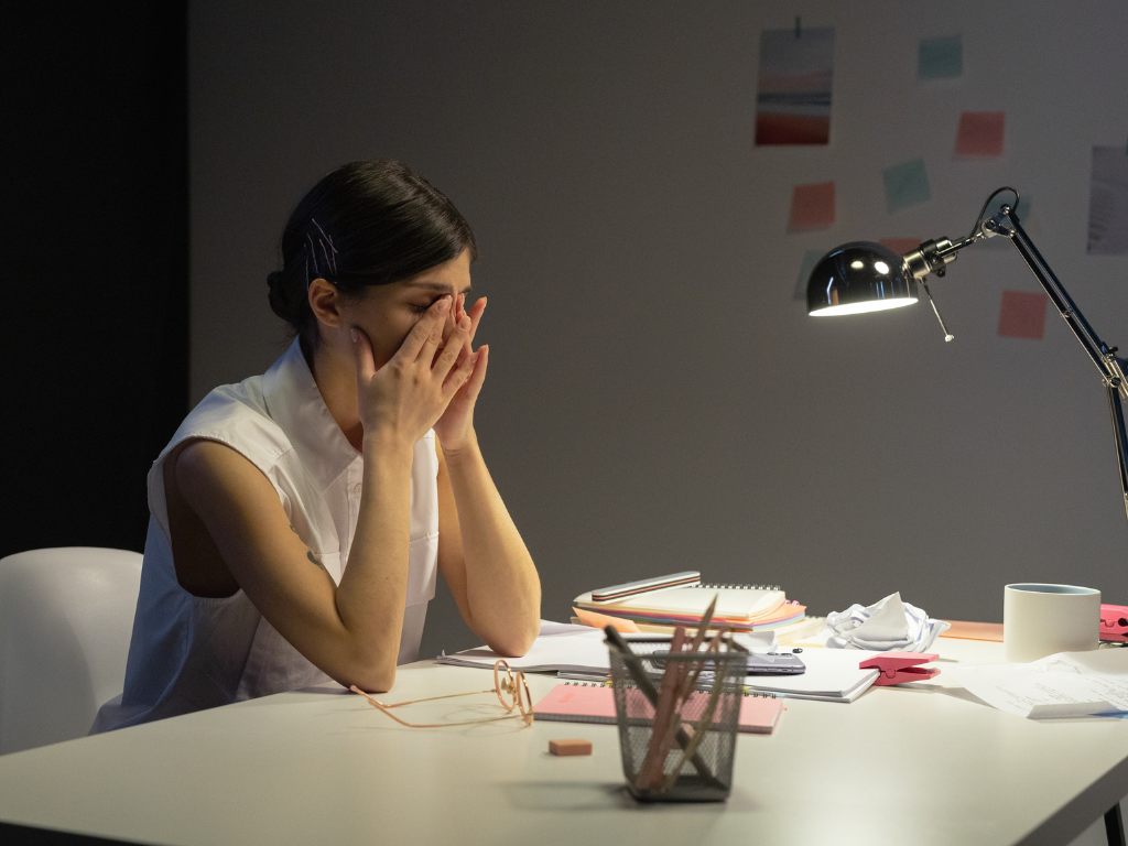 An image of a stressed-out employee at her work desk