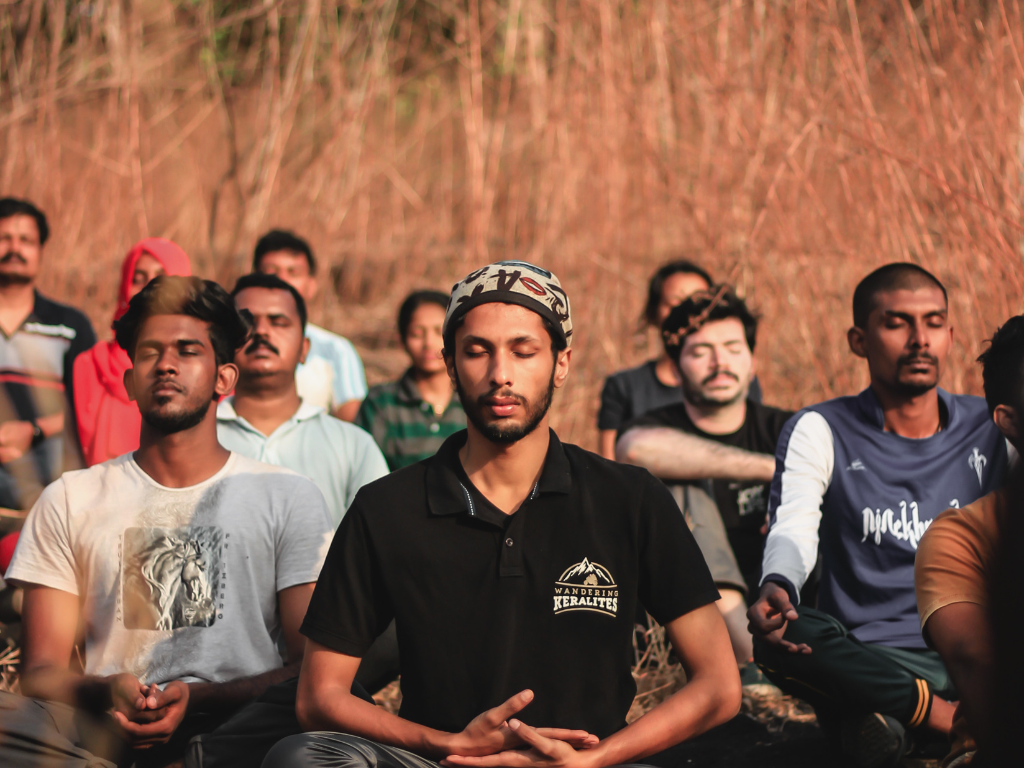 A set of people performing meditation near a meditation centre