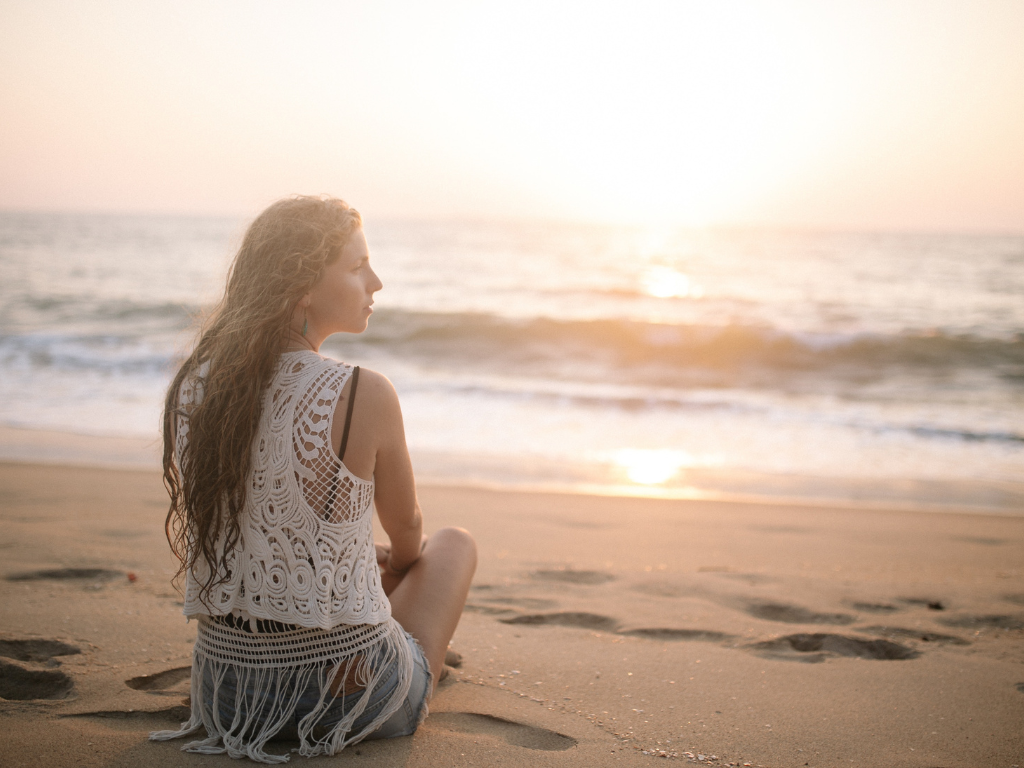 An image of a woman nearby a seashore practicing meditation