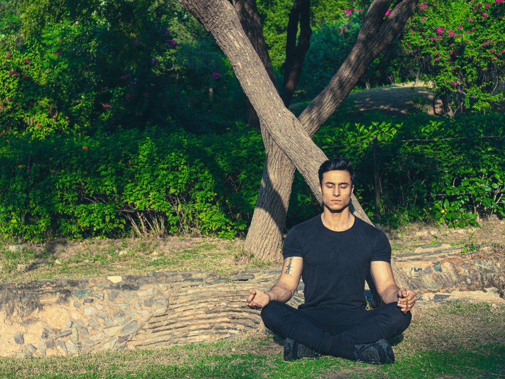 An image of a man performing meditation on the outdoor