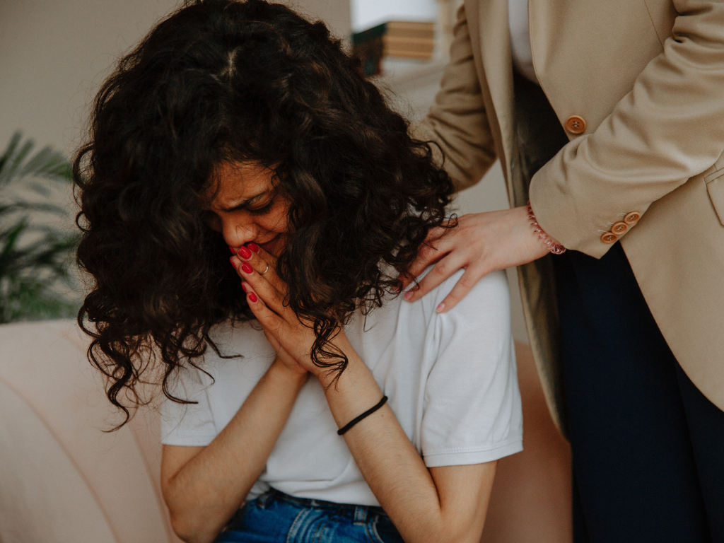 An empathetic woman trying to console another woman