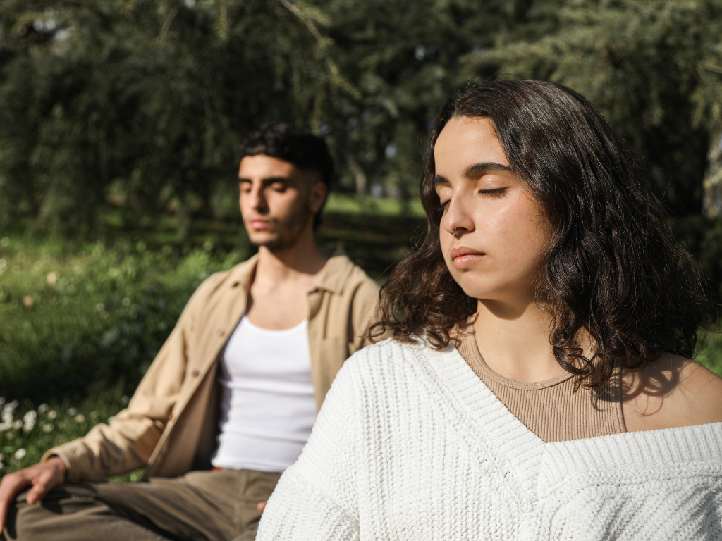 An image of a couple meditating in the outdoors