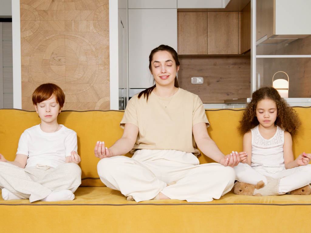 An image of a woman with her children practicing Heartfulness meditation