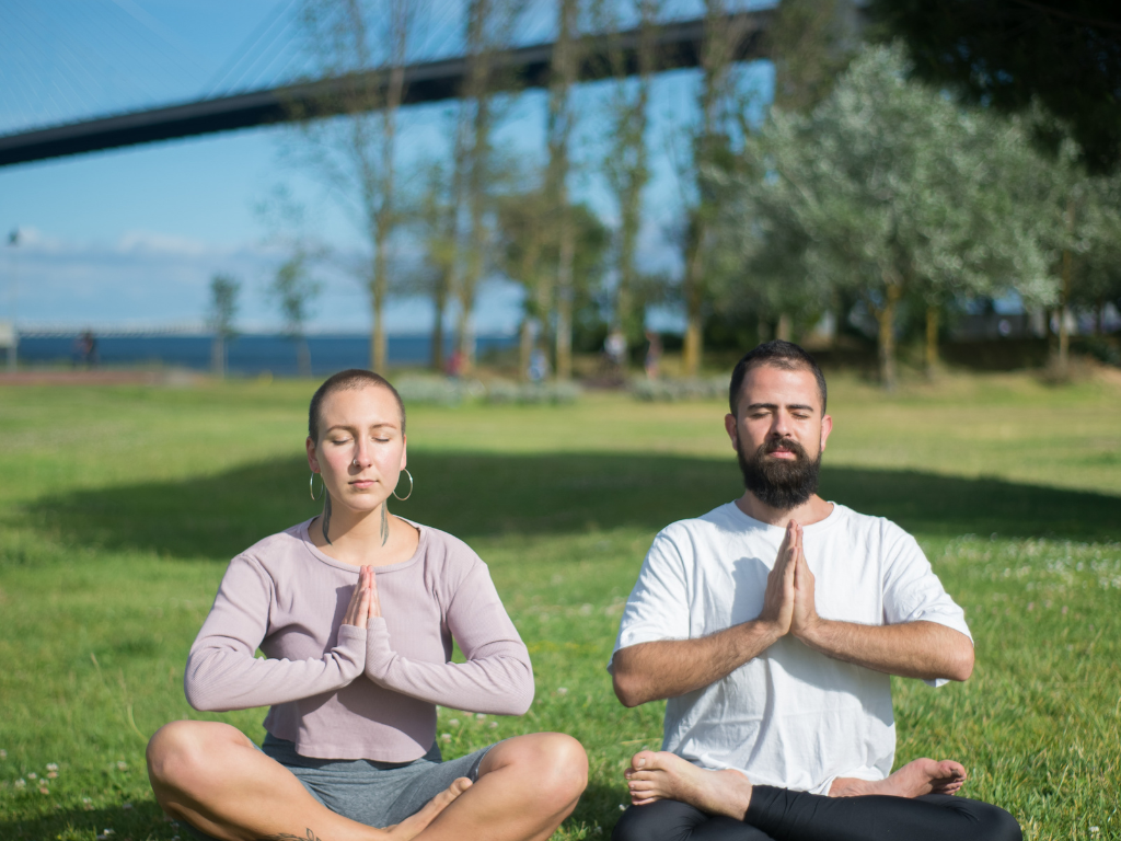 An image of a man and a woman performing guided meditation
