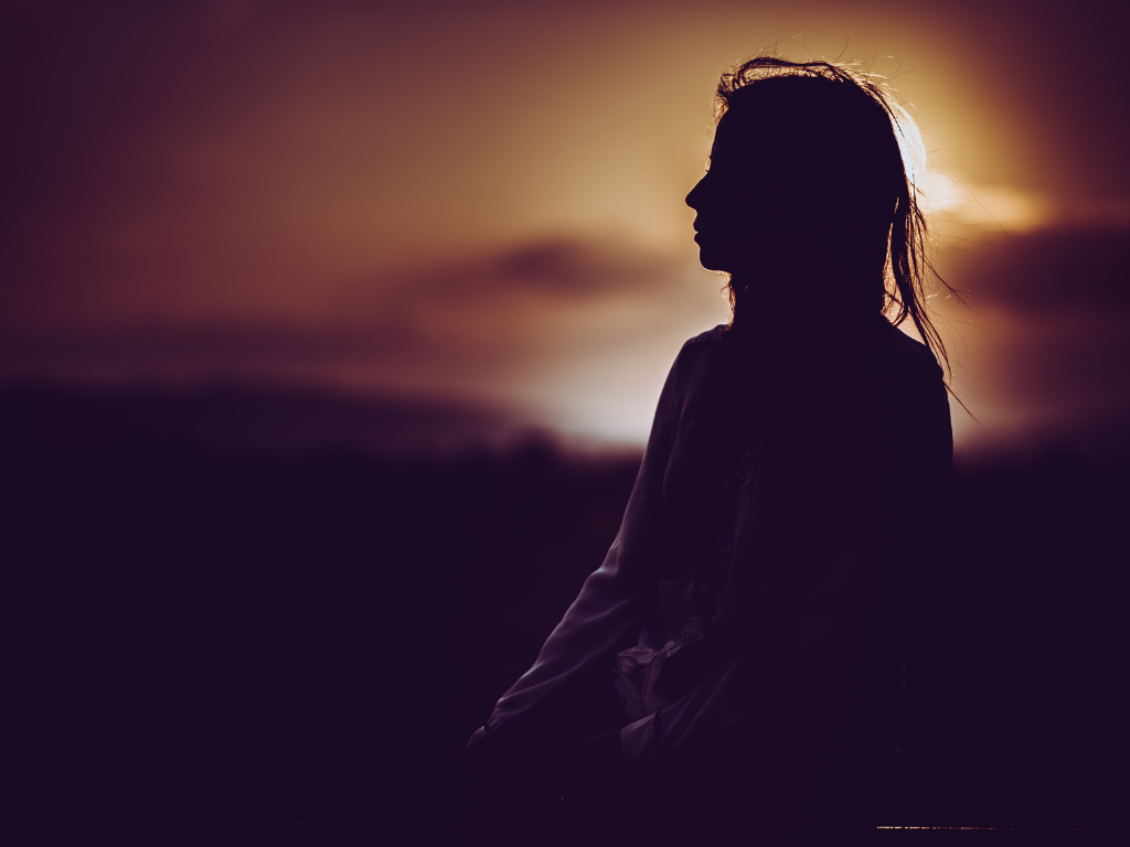 A silhouette image of a woman performing Heartfulness meditation