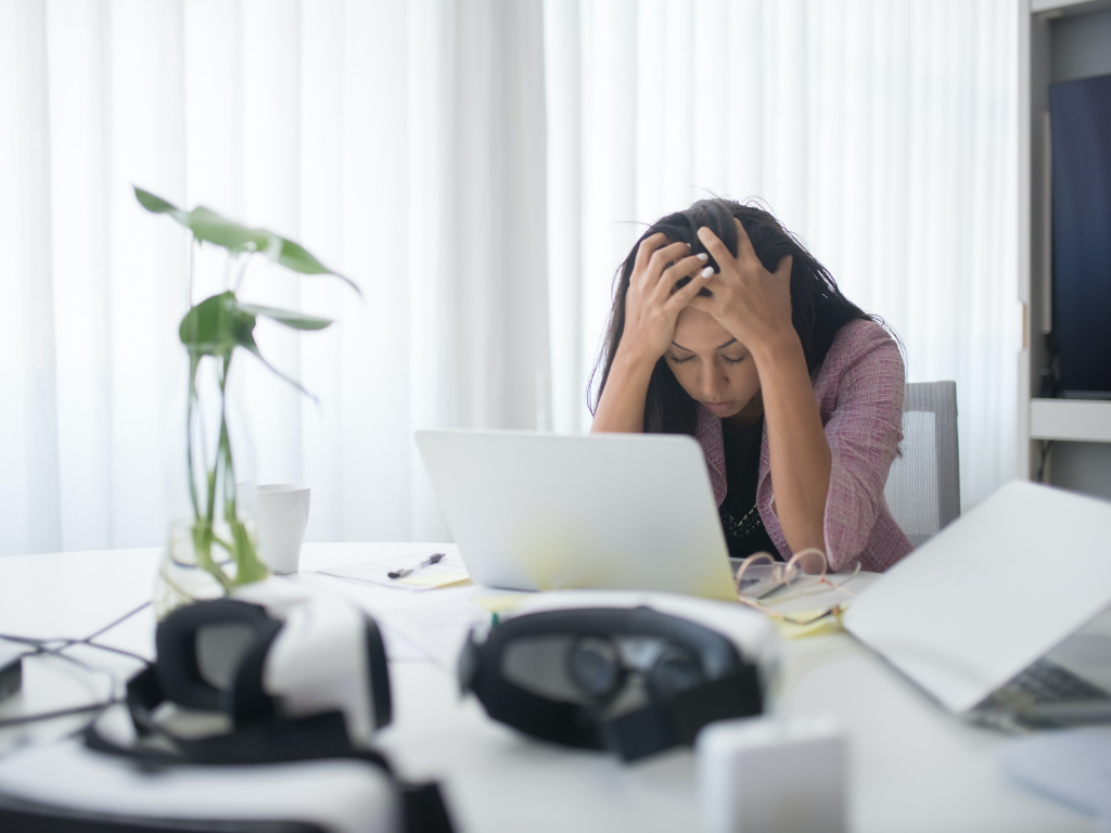An image of a stressed-out woman at her workspace.
