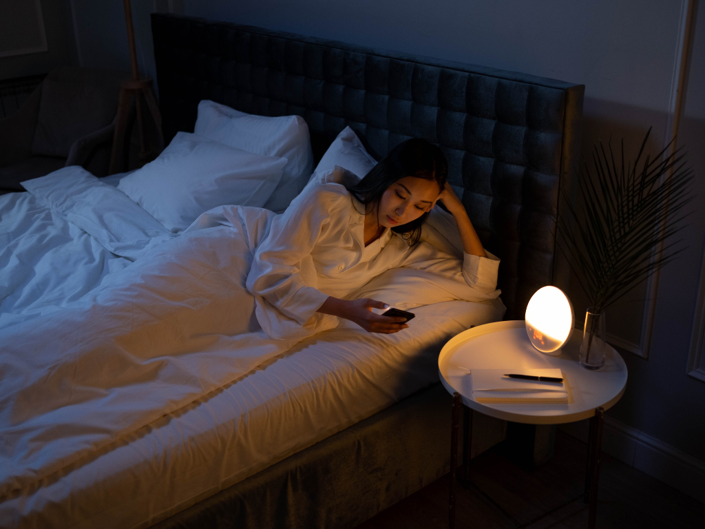 An image of a sleepless woman with her phone